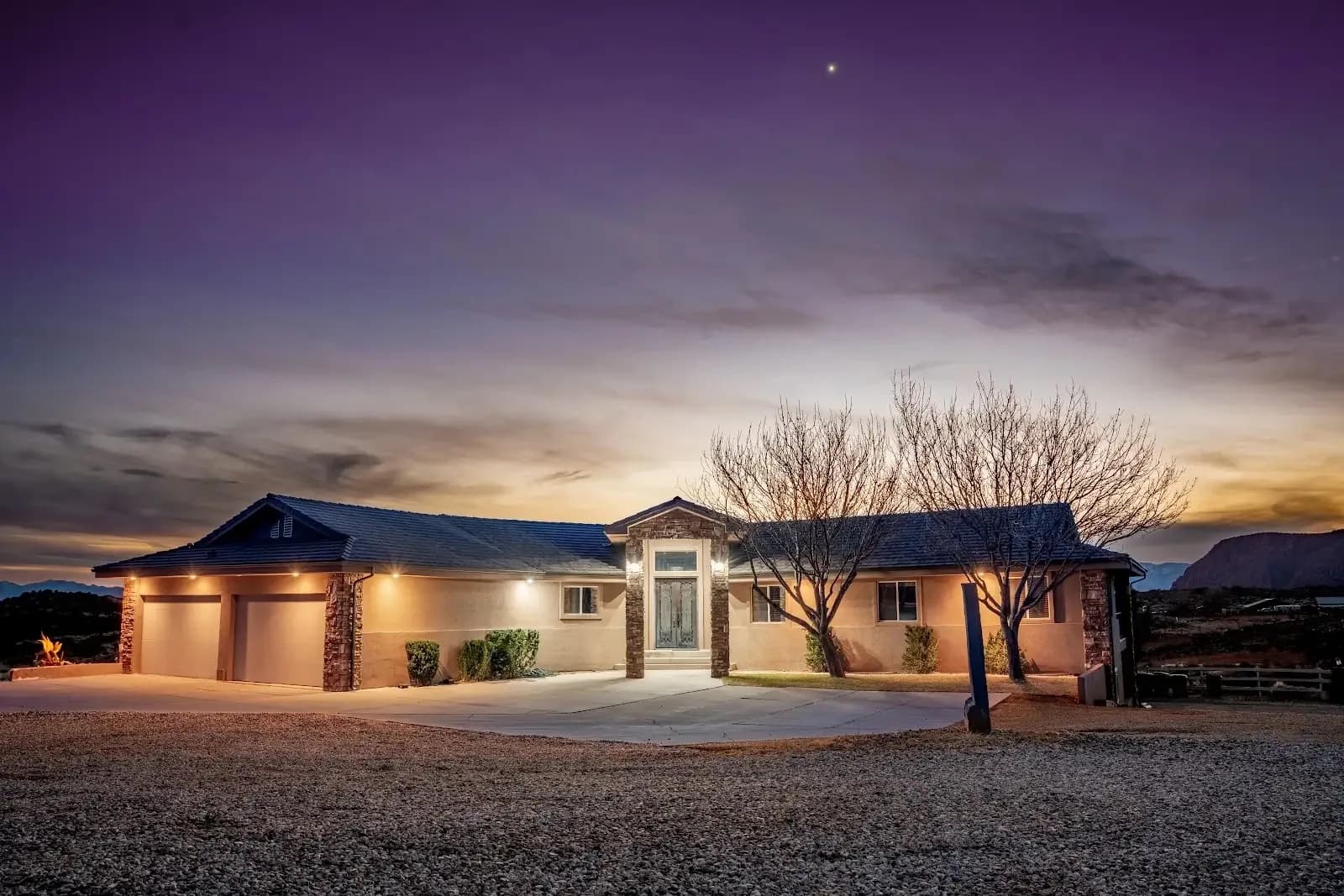 Renaissance Ranch St. George men's residential house at twilight, with red rock bluffs behind it