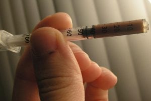 A syringe full of heroin is measured in someone's hands